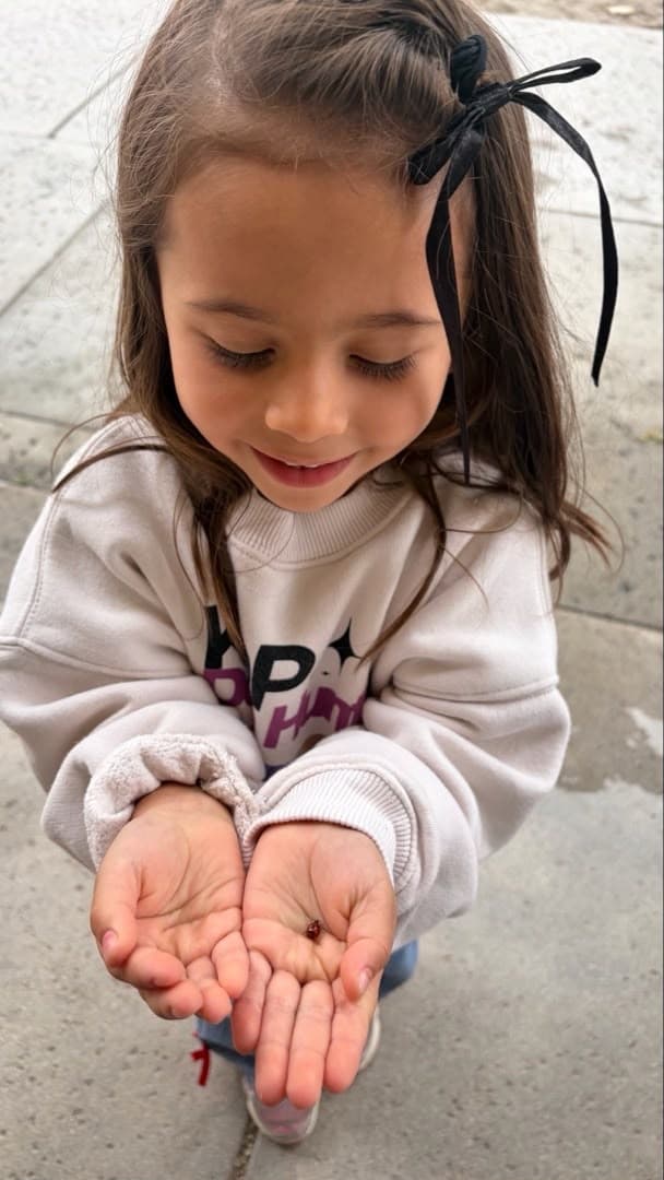 Student examining a ladybug found during outdoor nature exploration